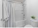 Clean, white bathroom featuring a tub-shower combo with modern fixtures and neutral accents at 705 Prince Dr, Holly Springs, NC 27540