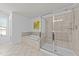Well-lit bathroom featuring a separate shower and tub, tile flooring, and bright white walls at 705 Prince Dr, Holly Springs, NC 27540