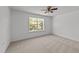 Comfortable bedroom featuring plush carpet, a ceiling fan, and bright window views of the outdoors at 705 Prince Dr, Holly Springs, NC 27540