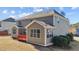 The rear exterior of this two-story home includes a sunroom and charming red deck at 705 Prince Dr, Holly Springs, NC 27540