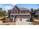 Beautiful two-story brick home with a welcoming front porch and three-car garage at 705 Prince Dr, Holly Springs, NC 27540