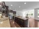 Open-concept kitchen with granite island, dark wood cabinetry, and stainless steel refrigerator at 705 Prince Dr, Holly Springs, NC 27540
