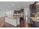 Open kitchen layout featuring a large island, stainless appliances and dark wood cabinets at 705 Prince Dr, Holly Springs, NC 27540