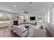 Bright living room featuring a fireplace, ceiling fan, large windows and stylish decor at 705 Prince Dr, Holly Springs, NC 27540