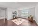 Sunlit living room features hardwood floors, a large window, and stylish décor, creating a welcoming space at 705 Prince Dr, Holly Springs, NC 27540