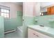 Bathroom featuring green tile, a tub, and patterned wallpaper at 709 S Sellars Mill Rd, Burlington, NC 27217