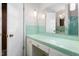 Bathroom featuring green tile, vanity with adjacent storage, and patterned wallpaper at 709 S Sellars Mill Rd, Burlington, NC 27217