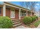 Charming brick home entrance with a covered porch and manicured bushes at 709 S Sellars Mill Rd, Burlington, NC 27217