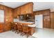 Kitchen with wood cabinets, breakfast bar, view into living room, and adjacent to the dining room at 709 S Sellars Mill Rd, Burlington, NC 27217