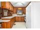 Eat-in kitchen with white appliances, wood cabinets, and adjacent to the dining room at 709 S Sellars Mill Rd, Burlington, NC 27217