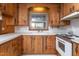 Kitchen area featuring wood cabinetry, white countertops and appliances, and bright natural light at 709 S Sellars Mill Rd, Burlington, NC 27217