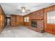 Cozy living room features a brick fireplace, wood paneling, and a ceiling fan at 709 S Sellars Mill Rd, Burlington, NC 27217