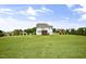 Extensive backyard featuring lush grass, mature trees, and a screened porch at 71 Del Corso Ct, Clayton, NC 27527