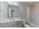 Bright bathroom features a bathtub with shower, a large mirror, and white vanity with cabinet space at 71 Del Corso Ct, Clayton, NC 27527