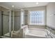 Elegant bathroom features a glass-enclosed shower, a soaking tub, and a large decorative window at 71 Del Corso Ct, Clayton, NC 27527