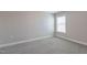 An empty bedroom with light gray carpet, a window, and neutral colored walls at 71 Del Corso Ct, Clayton, NC 27527