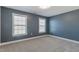 A bright, empty bedroom with blue walls and two windows at 71 Del Corso Ct, Clayton, NC 27527