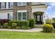 Close-up of a home's front entrance with a stone accent wall and well-maintained landscaping at 71 Del Corso Ct, Clayton, NC 27527