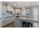 This kitchen boasts stainless steel appliances, white cabinetry, granite countertops, and a large center island with seating at 71 Del Corso Ct, Clayton, NC 27527