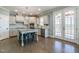 The kitchen has stainless steel appliances, white cabinetry, granite countertops, island seating and access to a deck at 71 Del Corso Ct, Clayton, NC 27527