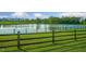 Scenic pond with green grass and a wooden fence, offering a serene view at 71 Del Corso Ct, Clayton, NC 27527