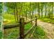 A property line is marked by a wooden fence as it enters a lush forest at 71 Del Corso Ct, Clayton, NC 27527
