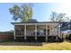 Covered back porch featuring a ceiling fan and outdoor seating area overlooking backyard at 717 Penn Rd, Raleigh, NC 27604