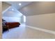 Spacious carpeted room with sloped ceilings and a glimpse of the bedroom with a bed at 717 Penn Rd, Raleigh, NC 27604