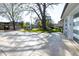 Wide driveway with a basketball hoop and lush trees adjacent to a side-entry two-car garage at 717 Penn Rd, Raleigh, NC 27604