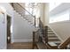 Grand foyer with hardwood floors, decorative chandelier, staircase with iron railings, and natural light at 717 Penn Rd, Raleigh, NC 27604