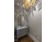 Stylish powder room with a marble countertop, gold accents, modern lighting fixture, and hardwood floors at 717 Penn Rd, Raleigh, NC 27604