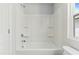 Clean white tiled shower/tub features built-in shelving and modern fixtures at 761 Portland Rose Dr, Knightdale, NC 27545
