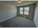 Empty bedroom with neutral carpet, two windows, and light walls at 761 Portland Rose Dr, Knightdale, NC 27545