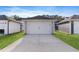 A detached two-car garage with a concrete driveway is surrounded by lush green grass and landscaping at 761 Portland Rose Dr, Knightdale, NC 27545