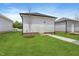 A view of the detached garage with white siding and black roof, enhanced by a well-maintained lawn at 761 Portland Rose Dr, Knightdale, NC 27545