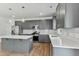 Modern kitchen features gray cabinets, stainless steel appliances, white countertops and an island at 761 Portland Rose Dr, Knightdale, NC 27545