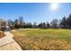Expansive backyard with lush lawn, trees, an outdoor playset, and inviting lounge chairs at 78 Rolling Meadows Ln, Chapel Hill, NC 27517