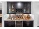 A bar area with dark wood cabinets, glass shelving, wine storage, and decorative holiday figurines at 78 Rolling Meadows Ln, Chapel Hill, NC 27517