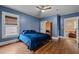 Cozy bedroom featuring classic hardwood floors, a ceiling fan, and a bright blue interior at 908 Spruce St, Durham, NC 27701