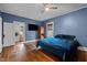 Comfortable bedroom with hardwood floors, ceiling fan and TV; laundry room is just steps away at 908 Spruce St, Durham, NC 27701