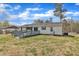 Expansive backyard featuring a deck, mature trees, and well-maintained lawn at 9817 Holly Springs Rd, Holly Springs, NC 27540