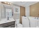 Updated bathroom featuring a walk-in tub, modern vanity, and neutral color palette at 9817 Holly Springs Rd, Holly Springs, NC 27540