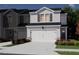 Exterior of new townhome showing a two-car garage, brown shutters, and green landscaping at 1173 Abbott St, Mebane, NC 27302