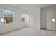 Bright bedroom featuring neutral carpet, two windows with natural light, and a white door at 12 Rolling Banks Dr, Louisburg, NC 27549