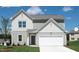 Charming two-story home featuring board and batten and horizontal siding and a two-car garage at 12 Rolling Banks Dr, Louisburg, NC 27549
