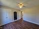 A bedroom with a ceiling fan and a closet features dark brown wood flooring at 120 Keith Ct, Willow Springs, NC 27592