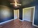 Modest bedroom with ceiling fan, closet, and wood-look flooring in need of repairs at 120 Keith Ct, Willow Springs, NC 27592