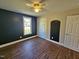A bedroom features a ceiling fan, a window, a closet and a door with dark brown wood flooring at 120 Keith Ct, Willow Springs, NC 27592