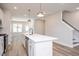 Open-concept kitchen with a large white island, stainless steel appliances, and modern pendant lighting at 123 Weavers Grove Dr, Chapel Hill, NC 27514