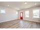 Bright living room with hardwood floors, neutral walls, a red door, and large windows offering natural light at 123 Weavers Grove Dr, Chapel Hill, NC 27514